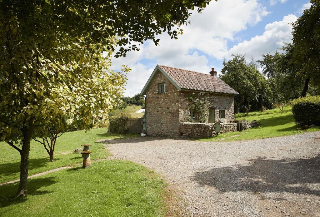 uma pequena casa de pedra no meio de um campo em Orchard Cottage Monmouthshire 