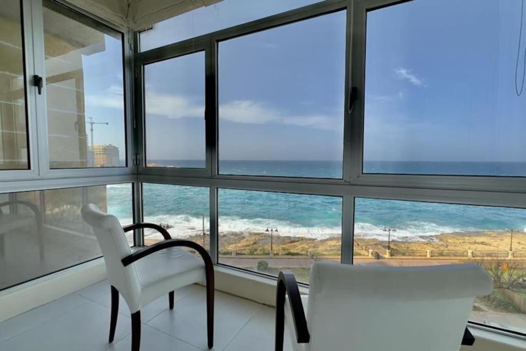 a white chair sitting in front of a window at sea view apartment on Sliema Promenade in Sliema