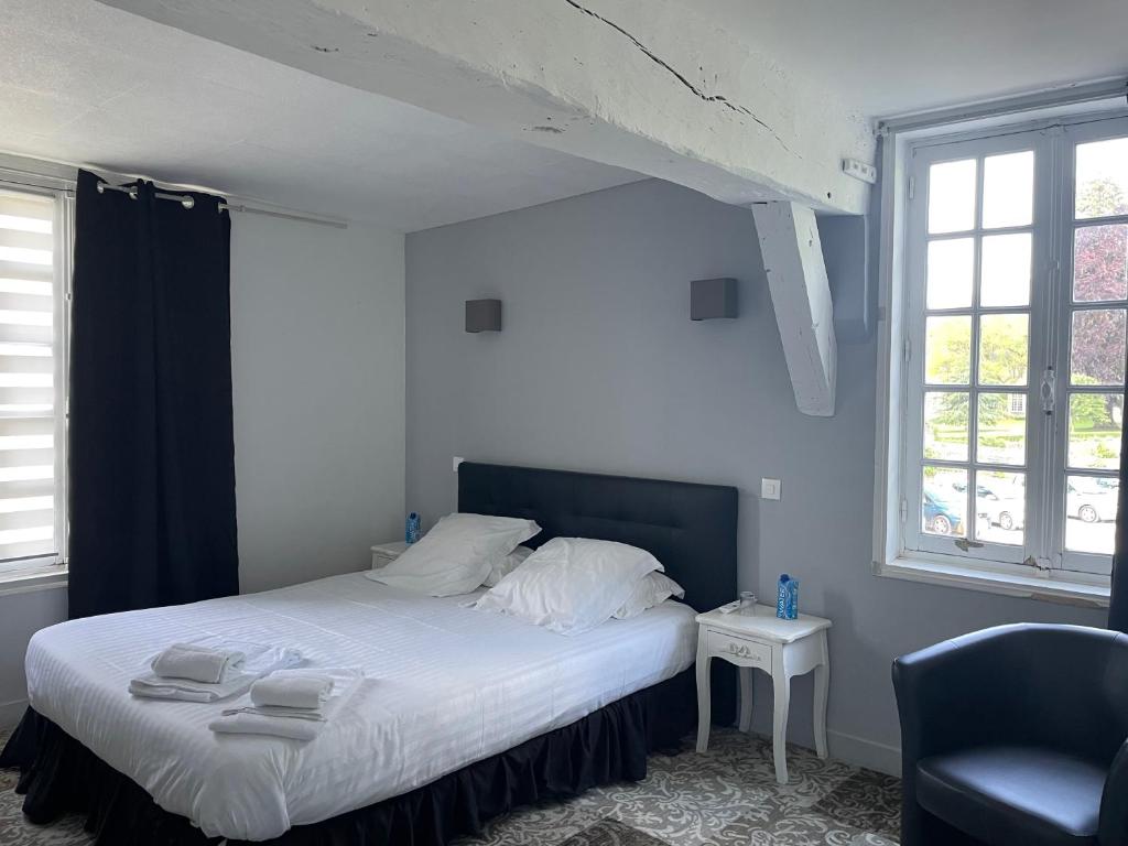 a bedroom with a bed with white sheets and a chair at Hôtel La Capitainerie in Châteauneuf-sur-Loire