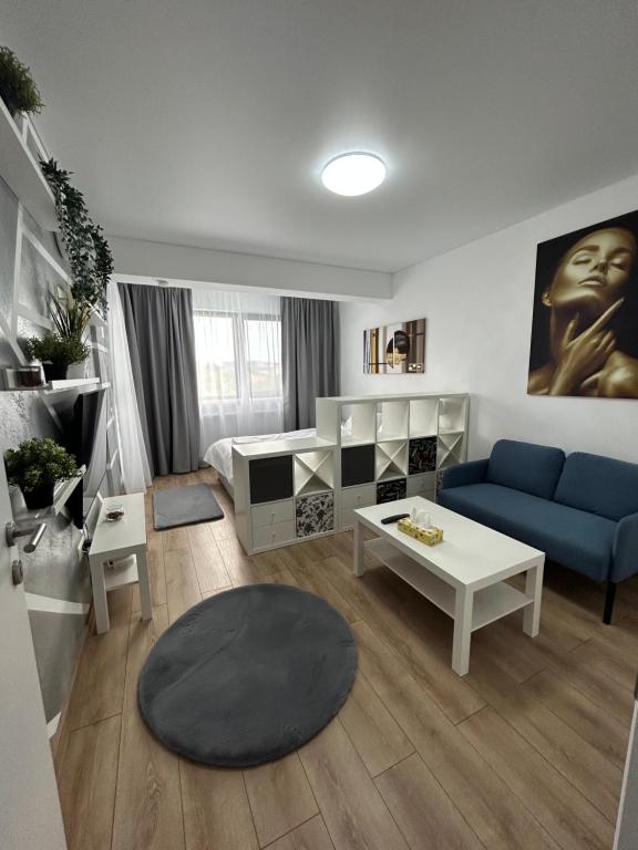 uma sala de estar com um sofá azul e uma mesa em Perla Home - Studio 22 em Popeşti-Leordeni