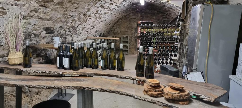 un montón de botellas de vino en una mesa con nevera en Le Belvédère - Chambres d'hôtes de charme et Restaurant, en Flassans-sur-Issole