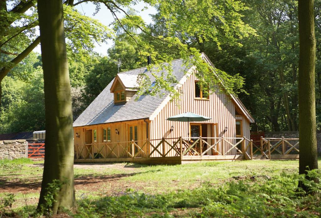 a house with a gambrel roof with a porch at Deerpark Lodge in Ashby de la Zouch