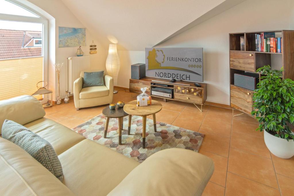 a living room with a couch and a tv at Exklusive Ferienwohnung Sonnenplatz 30 in Norddeich