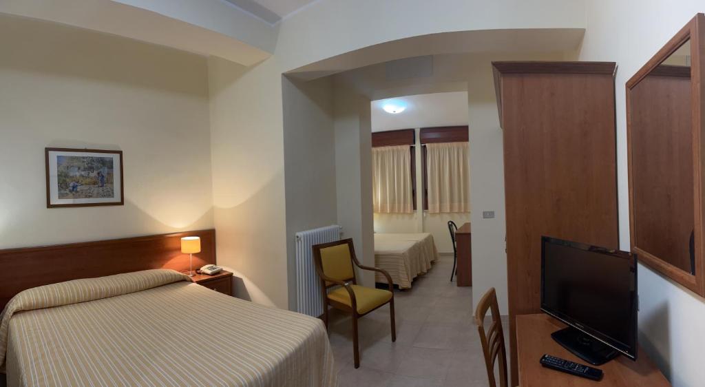 a hotel room with two beds and a flat screen tv at Il Nocchiero City Hotel in Soverato Marina