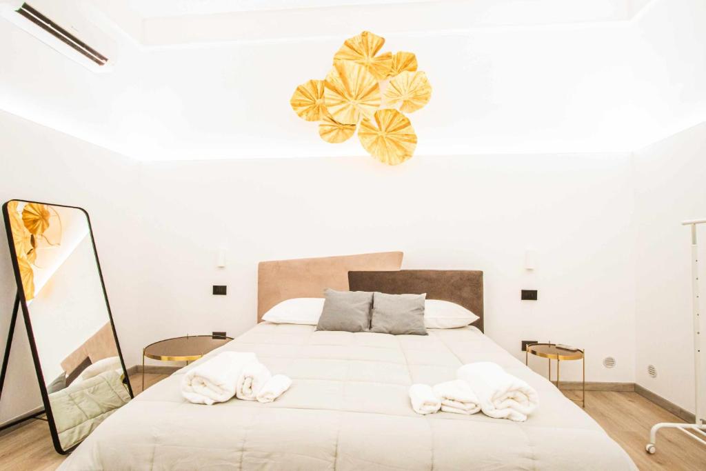 - une chambre avec un grand lit et des serviettes dans l'établissement Malià Sea House, à Bari