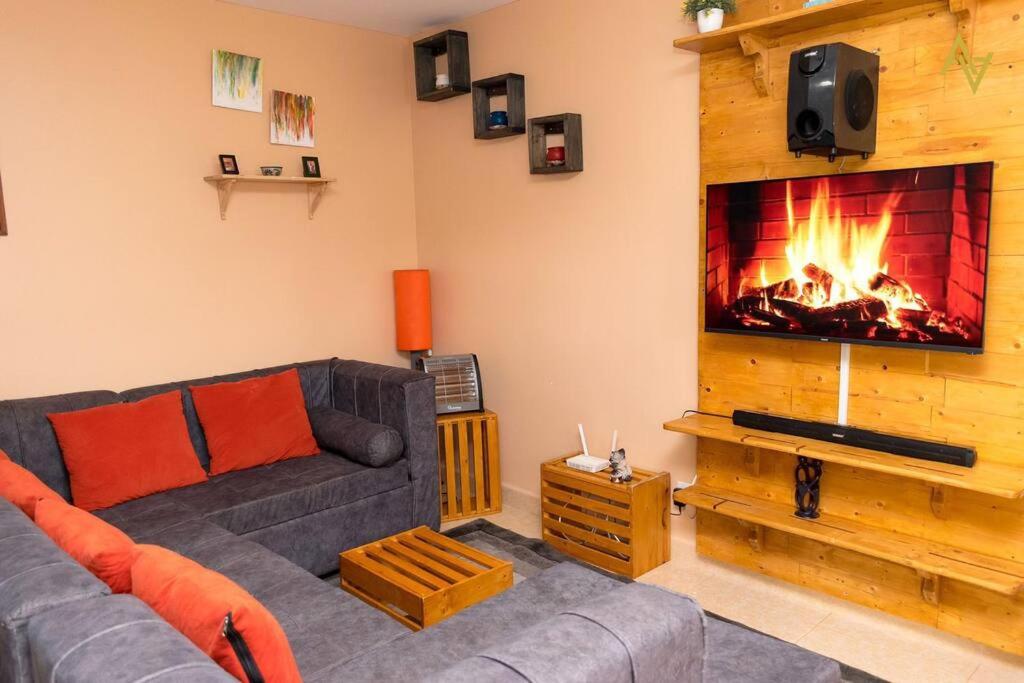 a living room with a couch and a fireplace at Cozy Nest Wi-Fi, Netflix call:0707070617 in Eldoret