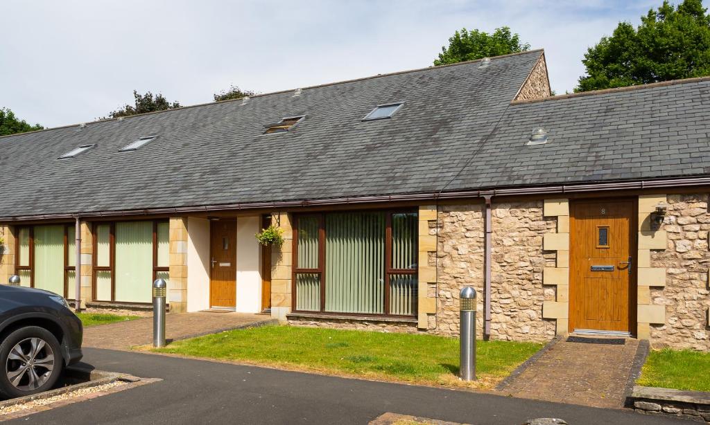 ein Steinhaus mit einem davor geparkt in der Unterkunft Tewitfield Marina in Carnforth