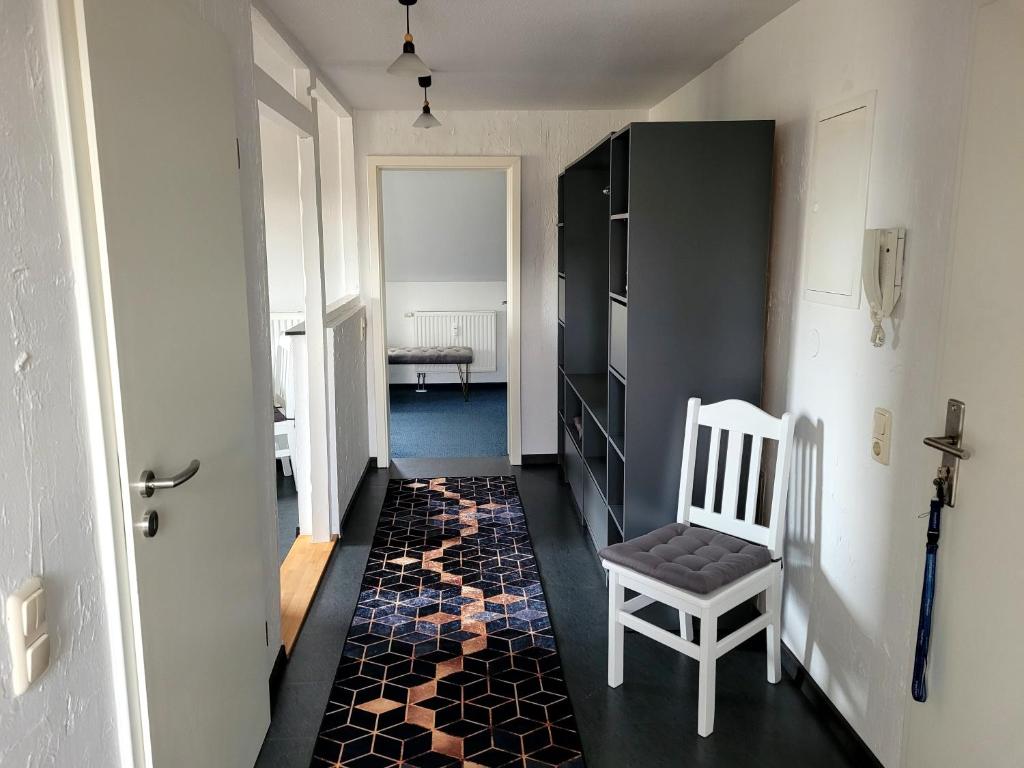 a hallway with a chair and a rug at gemütliche Ferienwohnung in Burgstaedt