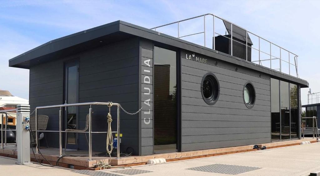 a small black building with a balcony at Hausboot La Mare Claudia in Weyhe