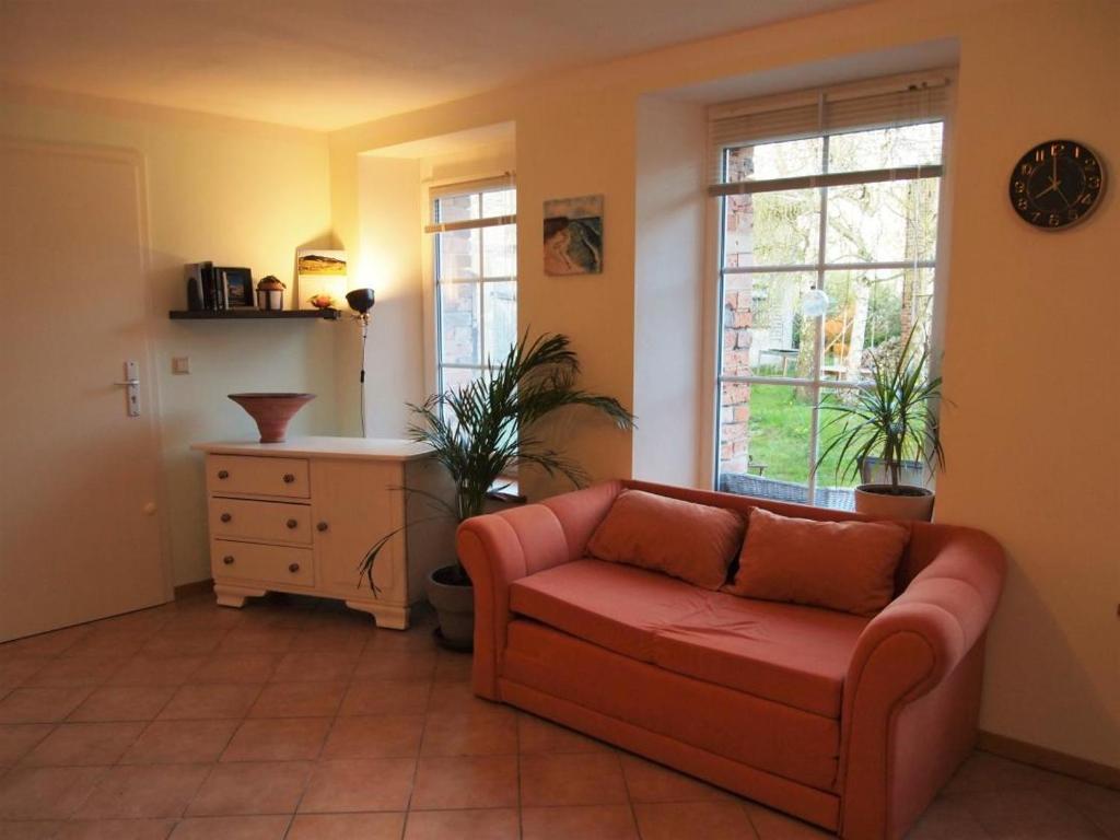 a living room with a couch and a window at NEU Fewo im Bauernhaus mit idyllischem Innenhof und Naturgarten in Mesekenhagen