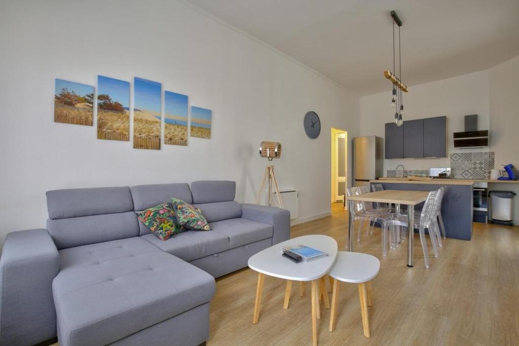 a living room with a couch and a table at Boulevard de la Plage flat in Arcachon