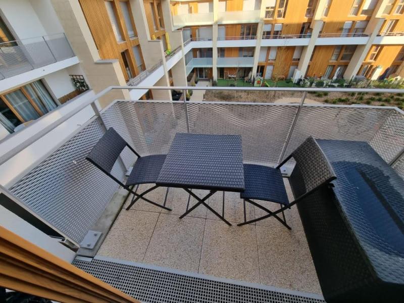 a balcony with a table and chairs on a balcony at Appart neuf entre Paris et Versailles, A 5 mn école Ducasse in Meudon