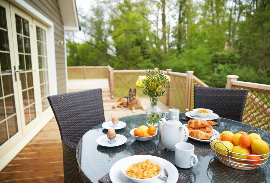 a table with plates of food on a patio at Brook Lodge Essex in Chappel