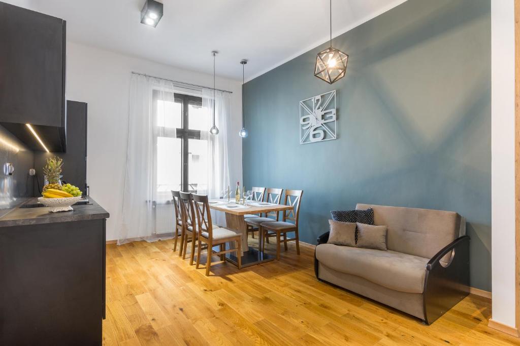 een keuken en eetkamer met een tafel en een bank bij Bridge Apartments 6 in Krakau