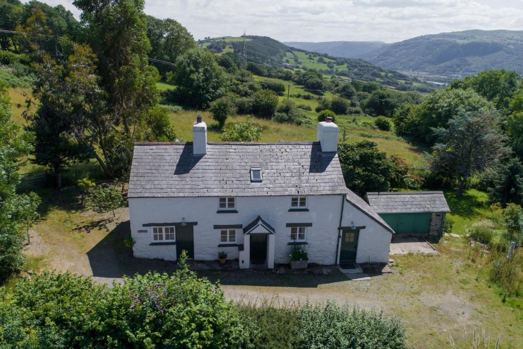an aerial view of a white house in the hills at Bryn Rhydd in Eglwys-Fâch