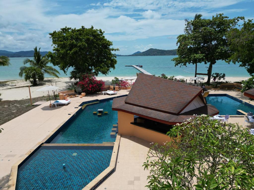 a swimming pool next to a beach with the ocean at Cruiser Island By Swiss-Belhotel in Ko Lone