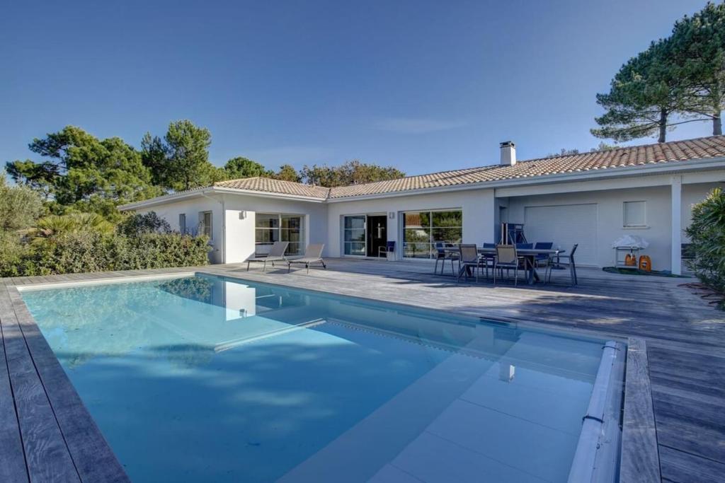 ein Pool vor einem Haus in der Unterkunft Villa du domaine au Pyla sur mer in La Teste-de-Buch