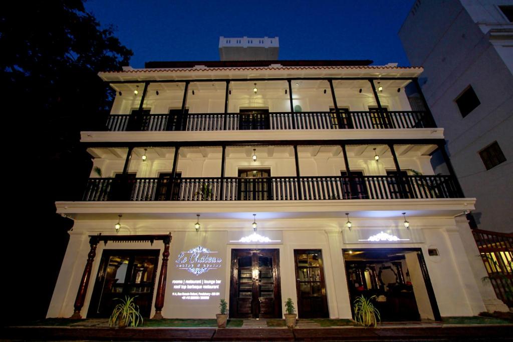 a white building with a balcony on top of it at Le Chateau in Puducherry