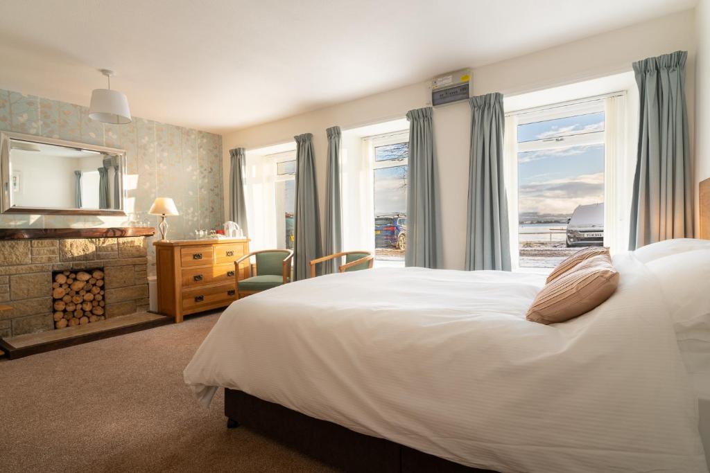 a bedroom with a bed and a large window at Harbour Guest House in Tobermory