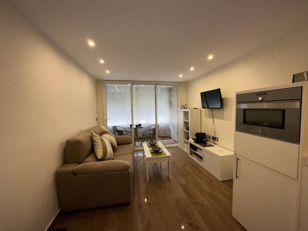 a living room with a couch and a television at studio Monserrate F in Torrevieja