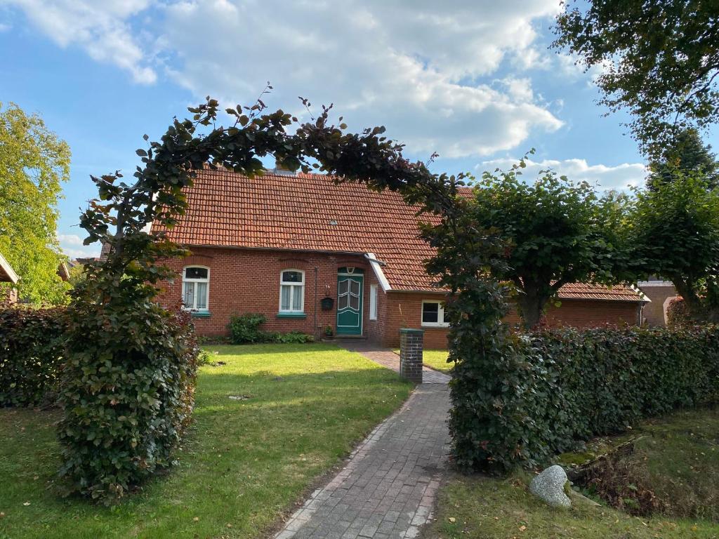 una casa de ladrillo con un arco delante de un patio en Ferienhaus Huus up Polder 65349, en Moormerland