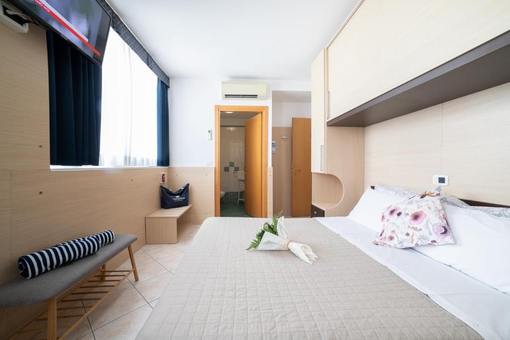 a bedroom with a large bed with a large window at Casa Merano Residence & Ristorante Bibione Centro in Bibione