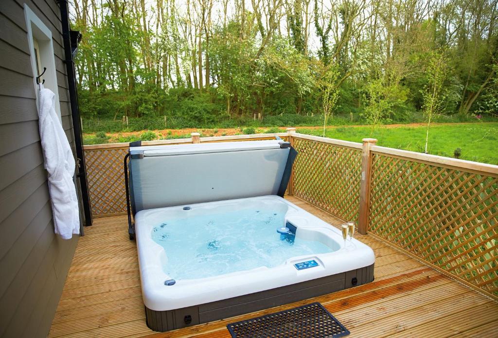 a hot tub on a deck with a view of a yard at Campion Lodge in Chappel