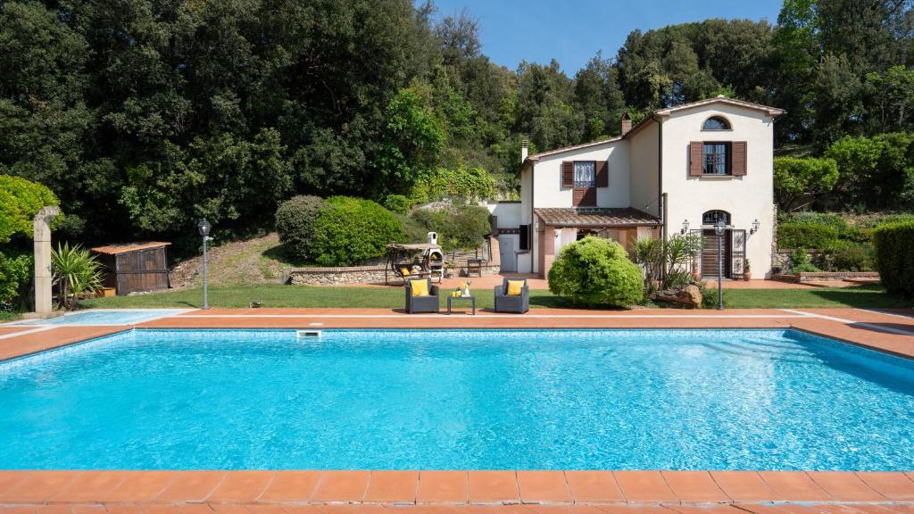 a swimming pool in front of a house at VILLA NIKKA 6, Emma Villas in Riparbella