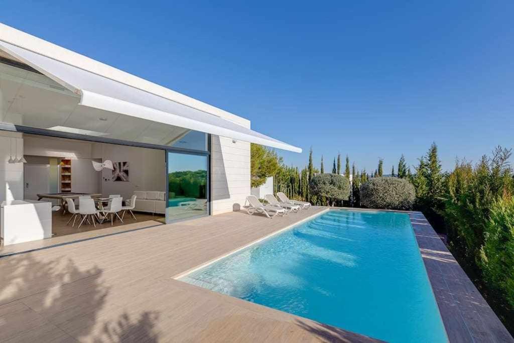 a swimming pool in the backyard of a house at Preciosa villa con la piscina en las Colinas in Orihuela