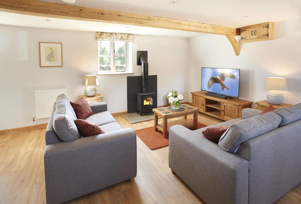 a living room with two couches and a fireplace at Pear Tree Cottage Shropshire in Orleton