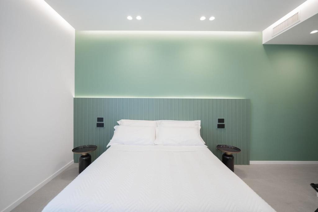 uma cama branca num quarto com paredes verdes em BMC Home em Boscotrecase