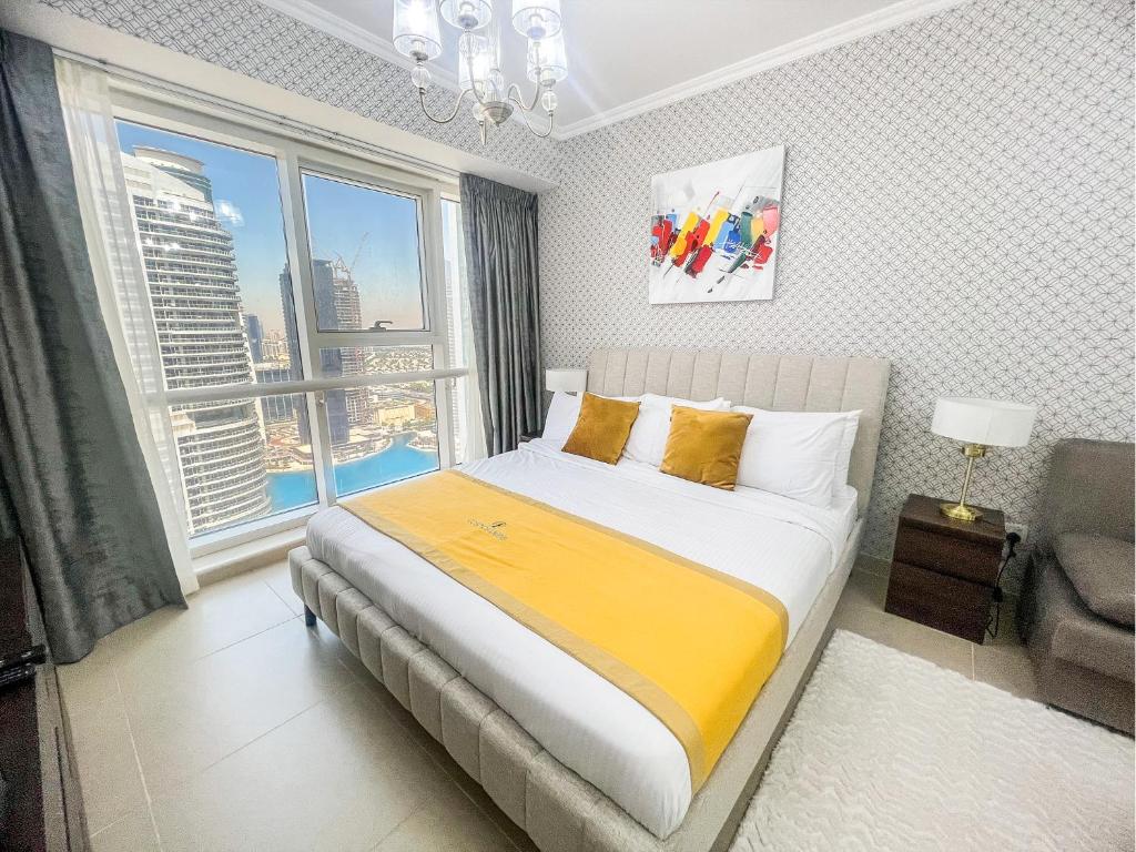 een slaapkamer met een bed en een groot raam bij Cosmos Living Modern Studio Near Dubai Marina in Dubai