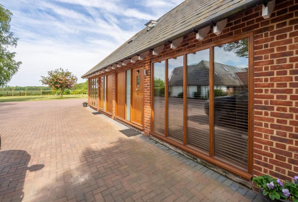 a brick building with large windows on the side of it at Beau View Cottage in Bekesbourne