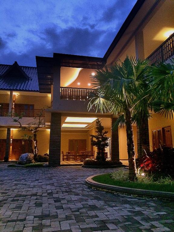 una casa con una palma di fronte di Syailendra Hotel Syariah a Jepara