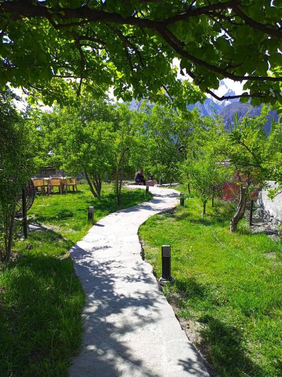 a path through a park with trees and grass at Grapes Garden Resort Hunza in Hunza Valley