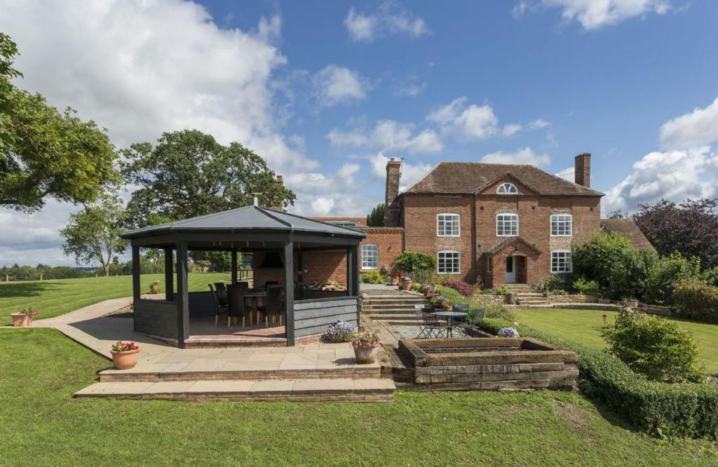 a house with a gazebo in the yard at Broad Meadows Farmhouse 12 Guests in Bayton