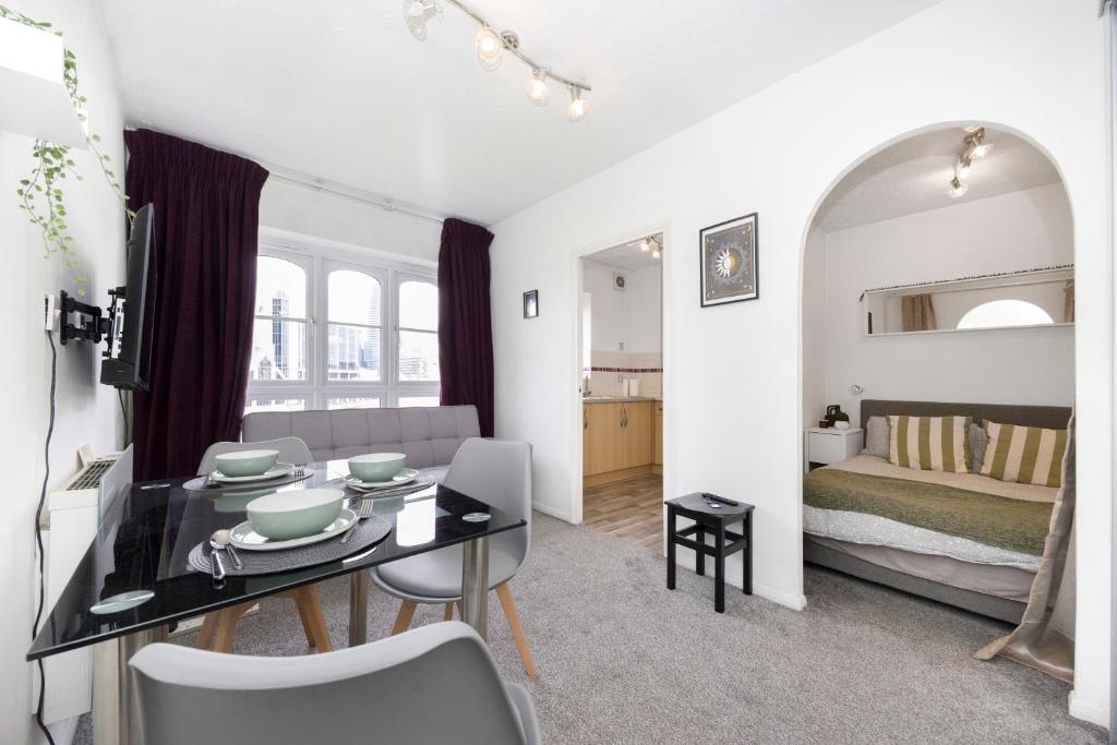 a room with a dining table and a bedroom at Verv Isle of Dogs in London