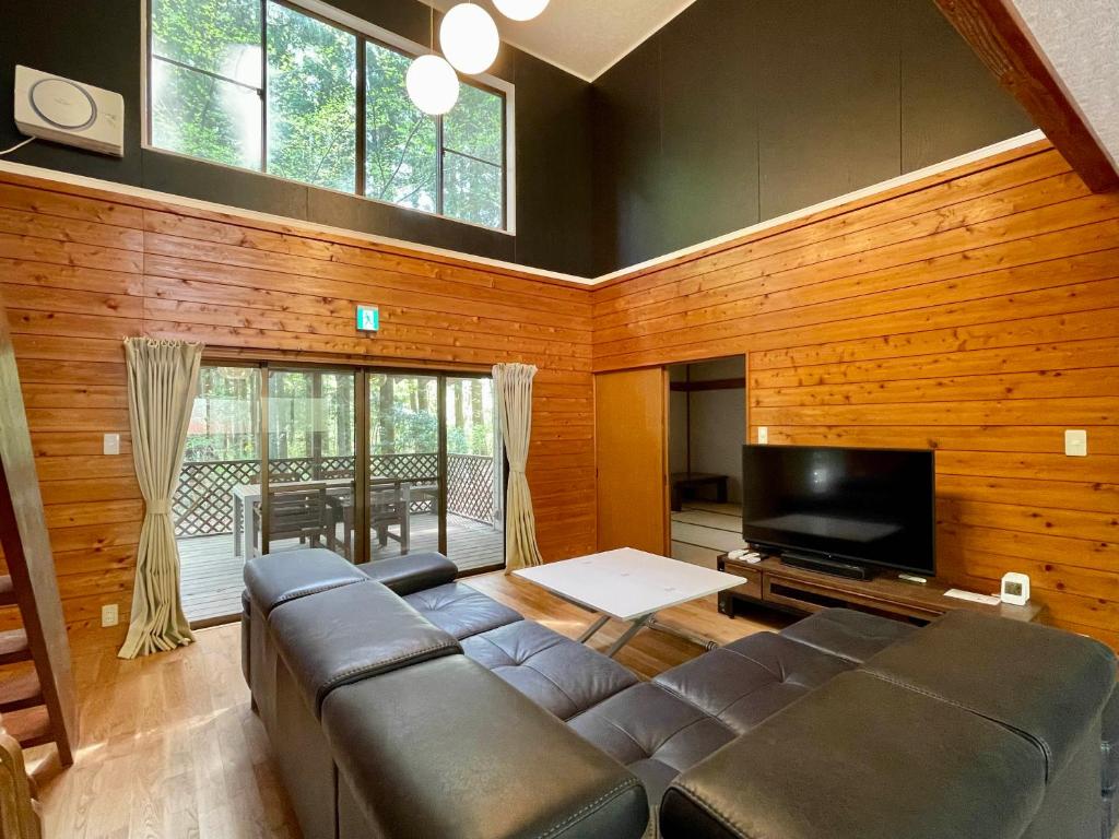 ein Wohnzimmer mit einem Sofa und einem Flachbild-TV in der Unterkunft 那須 - Nasu 369 MOMURA Cottage - ペット可 in Nasushiobara