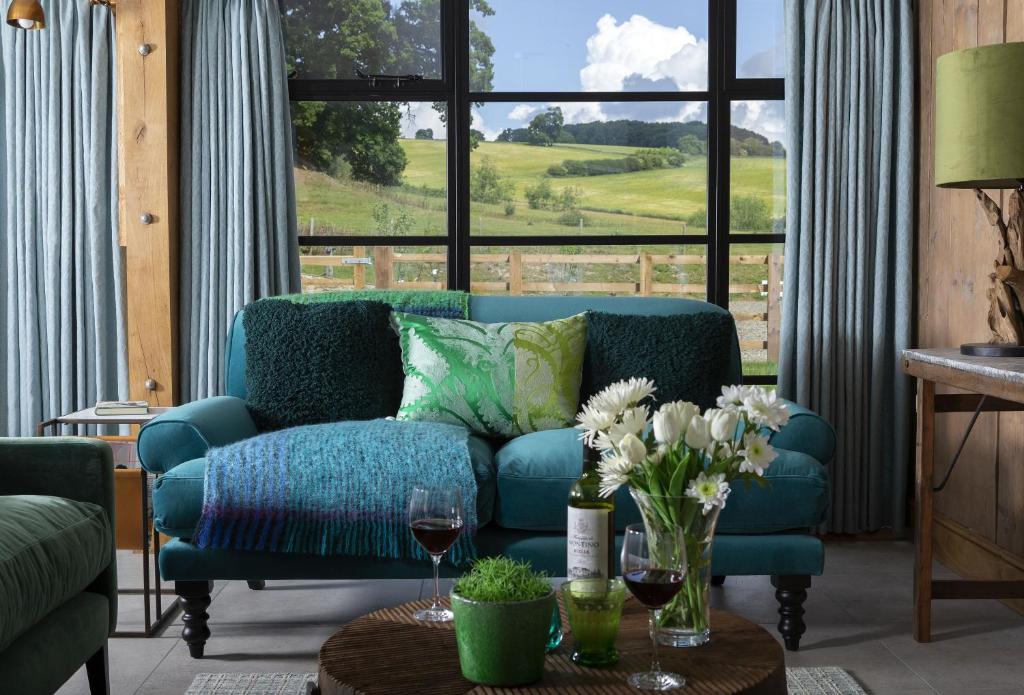 a living room with a blue couch and a window at The Timber Barn in Downton