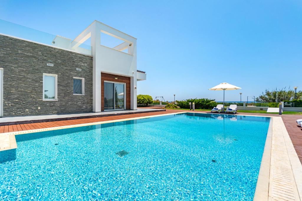 una piscina frente a una villa en Seafront Villa Maya by Ruidoso Luxury, en Ayia Napa