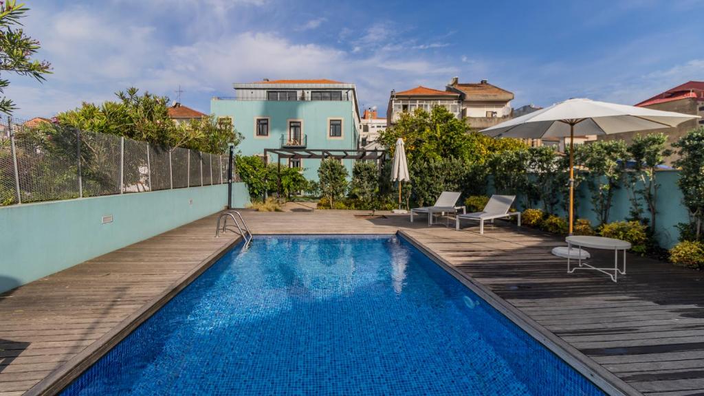 een huis met een zwembad en een houten terras bij LovelyStay - Downtown Studio with Pool, AC and Balcony in Porto