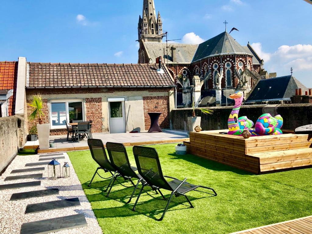 une cour avec des chaises et une fontaine en face d'un bâtiment dans l'établissement COC - La Maison Des Secrets, à Calais