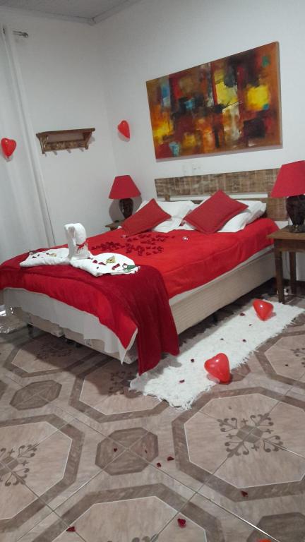 a bedroom with a bed with red hearts on the floor at Pouso do Manu in Tiradentes