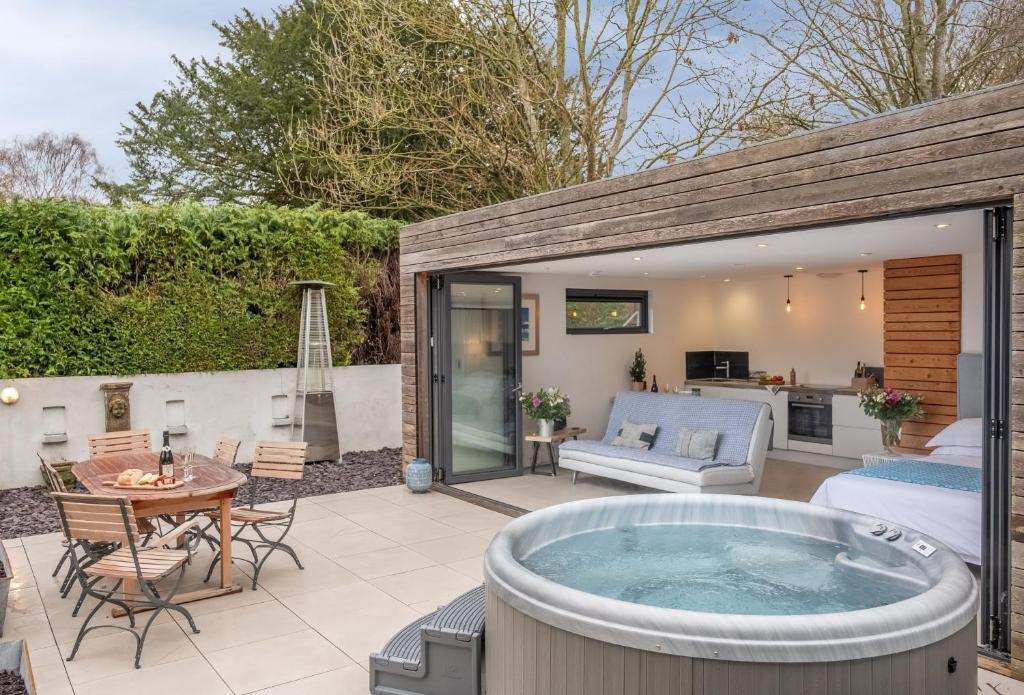 a hot tub on the patio of a house at 1 Church Cottages & Garden Room 