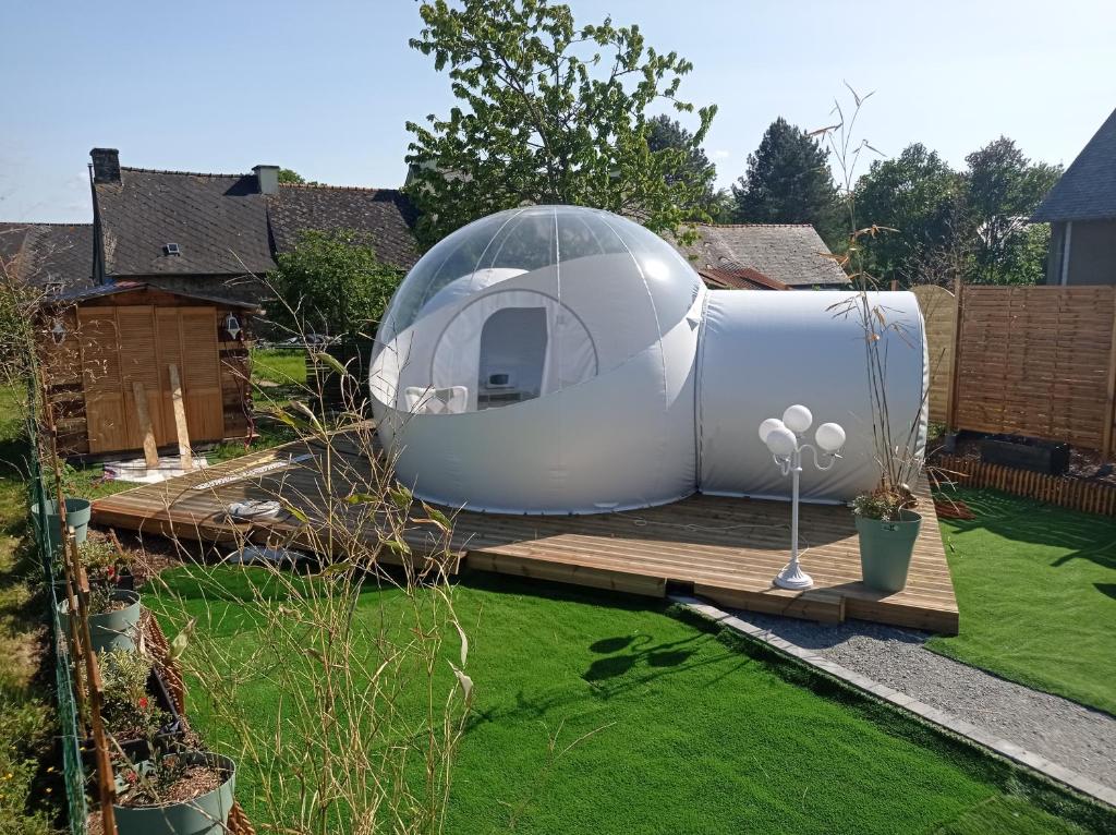 a dome house on a deck in a garden at Hé Ma Bulle in Pleugueneuc