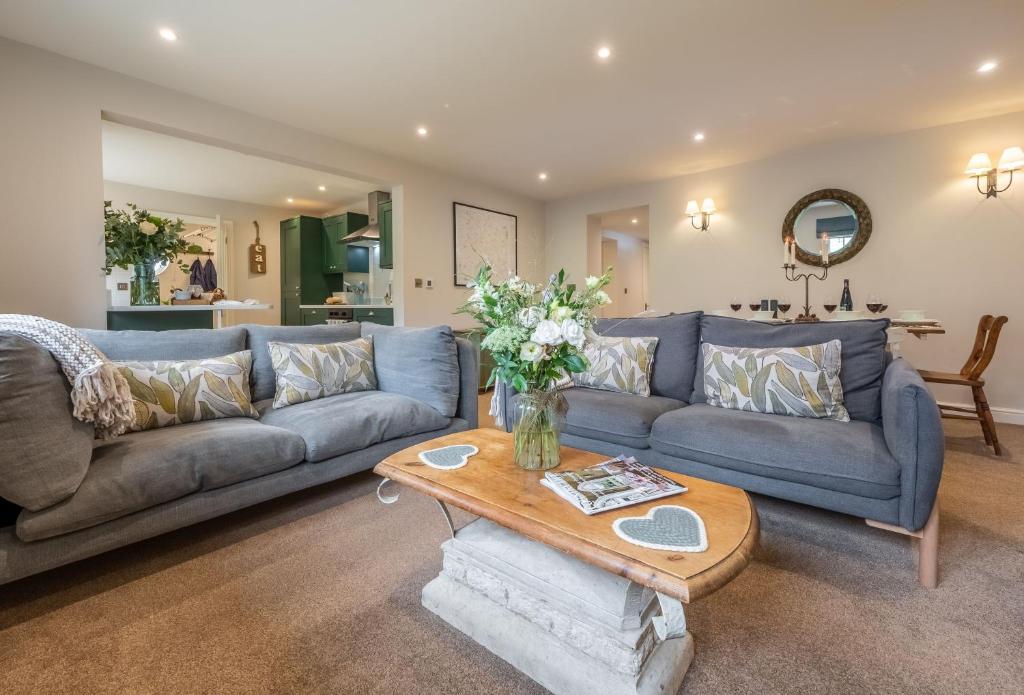 sala de estar con sofá azul y mesa en Stables Cottage en Tilton