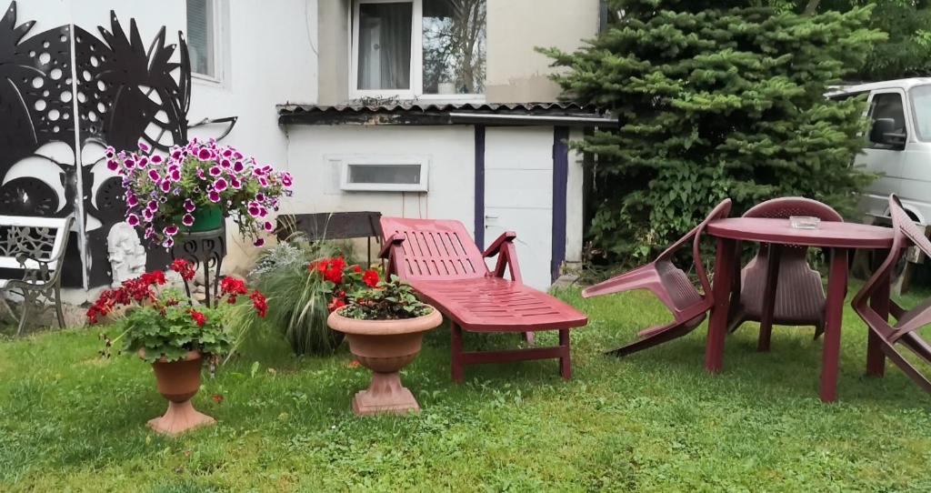 a garden with a table and chairs and flowers at Kambario nuoma namelyje in Kaunas