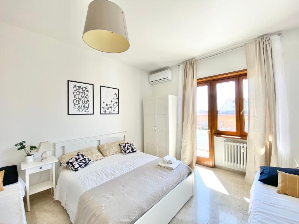 um quarto branco com uma cama e uma janela em Carducci Mare e Monti em Pescara