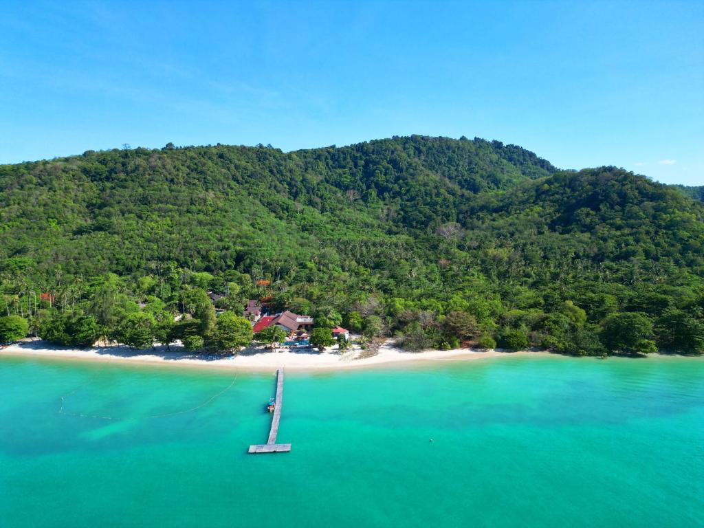 an island in the ocean with a boat in the water at Cruiser Island By Swiss-Belhotel in Ko Lone