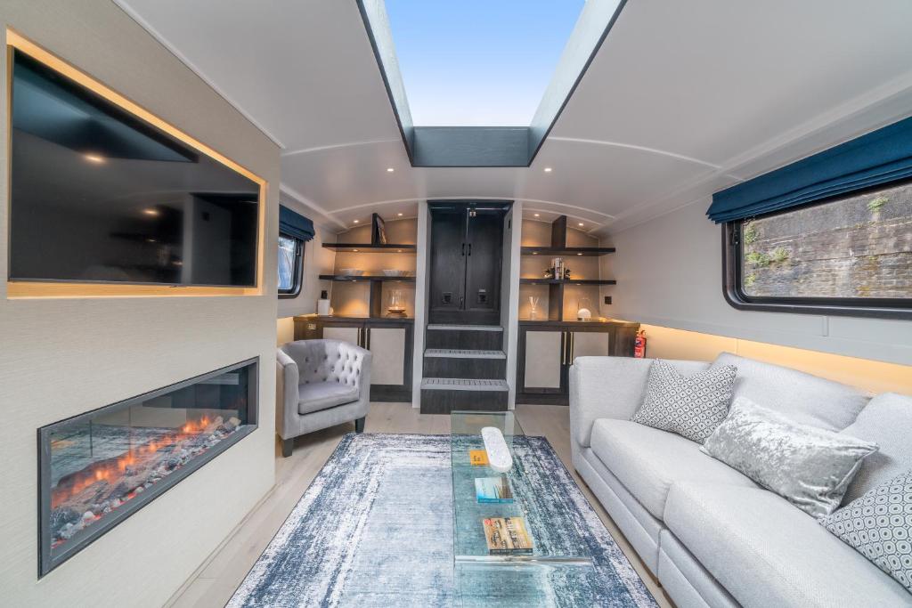 ALTIDO Elegant houseboat near Canary Wharf في لندن: غرفة معيشة مع أريكة ومدفأة